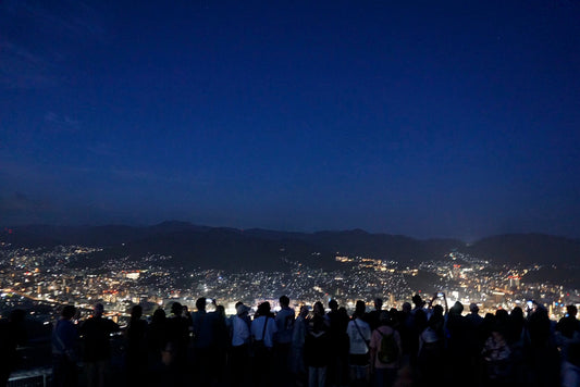 稲佐山の夜景に向けられるカメラ